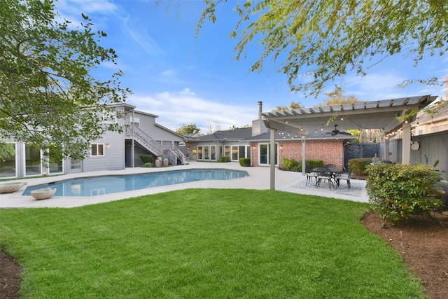 pool with a patio area, a lawn, stairs, and fence