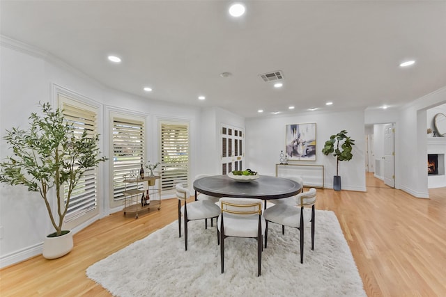 dining space with crown molding, recessed lighting, light wood-style floors, and visible vents