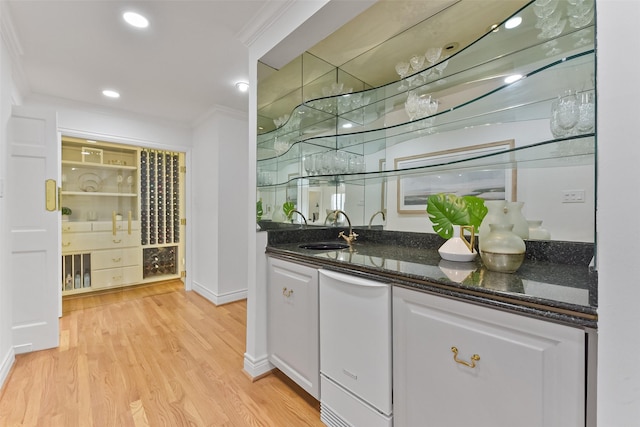 bar with crown molding, light wood-type flooring, recessed lighting, wet bar, and a sink