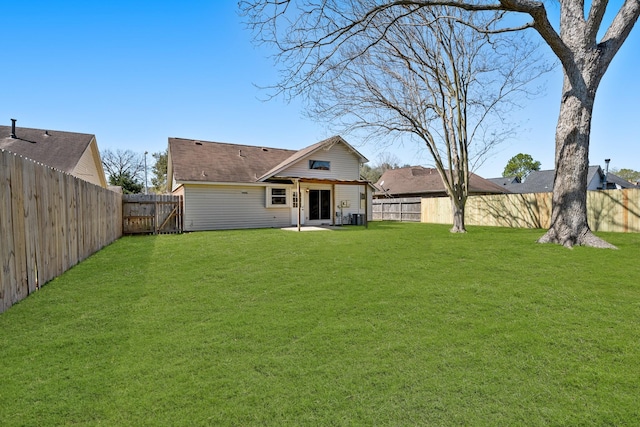 rear view of house with a yard, a patio, and a fenced backyard