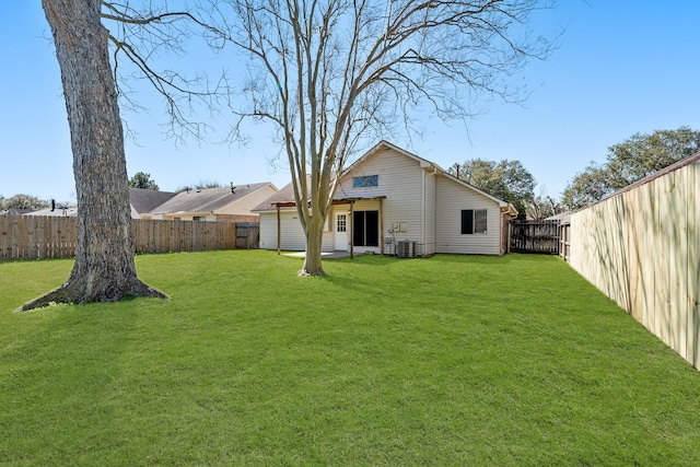 rear view of property with a yard and a fenced backyard