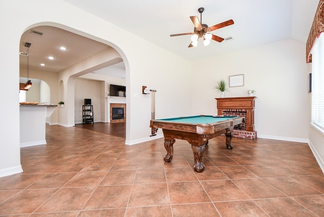 rec room featuring a fireplace, lofted ceiling, visible vents, baseboards, and tile patterned floors