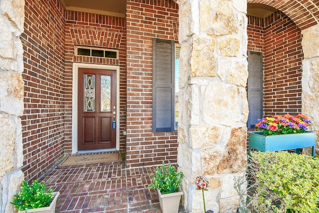 entrance to property with stone siding and brick siding