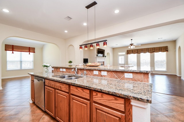 kitchen featuring a center island with sink, visible vents, stainless steel dishwasher, open floor plan, and a sink