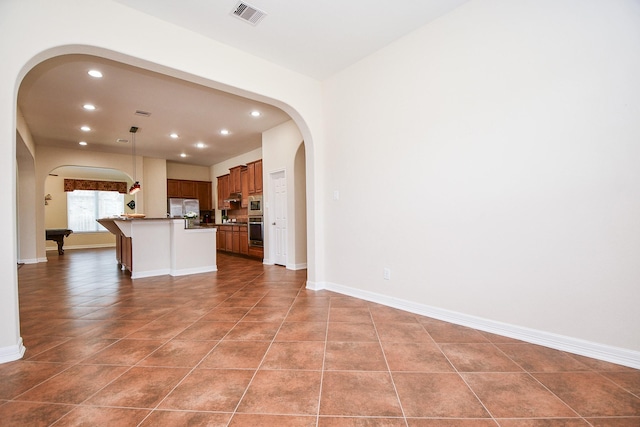 kitchen featuring arched walkways, recessed lighting, stainless steel appliances, visible vents, and baseboards