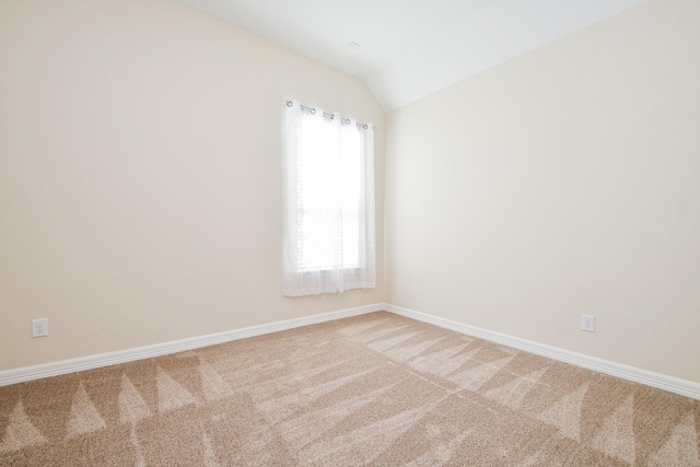 unfurnished room featuring vaulted ceiling, baseboards, and light colored carpet