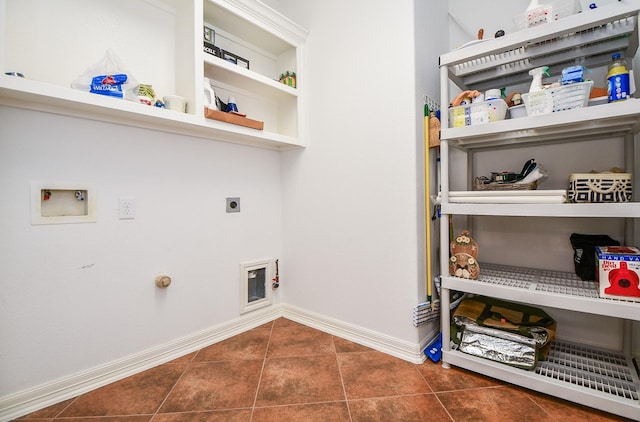 clothes washing area with laundry area, dark tile patterned flooring, hookup for a gas dryer, washer hookup, and electric dryer hookup