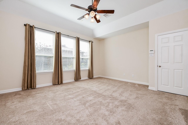 carpeted empty room with a ceiling fan, visible vents, and baseboards