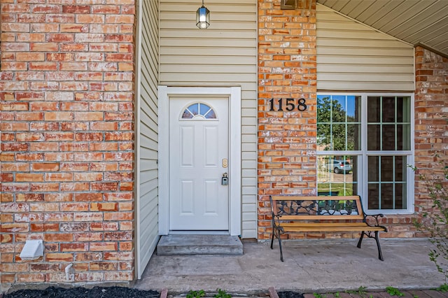 view of exterior entry featuring brick siding