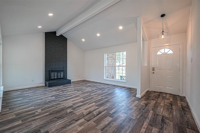 entrance foyer featuring baseboards, dark wood finished floors, vaulted ceiling with beams, a brick fireplace, and recessed lighting