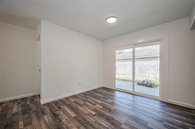 empty room featuring dark wood-style floors and baseboards