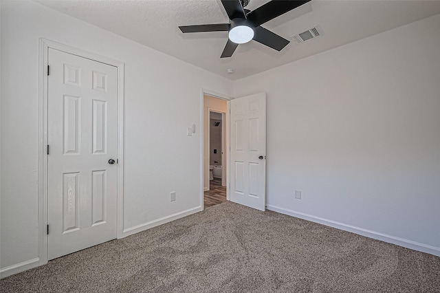 unfurnished bedroom with a ceiling fan, carpet flooring, visible vents, and baseboards