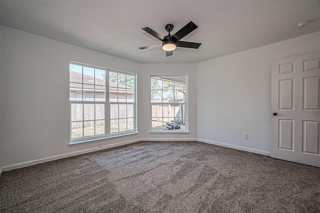 carpeted spare room with ceiling fan and baseboards