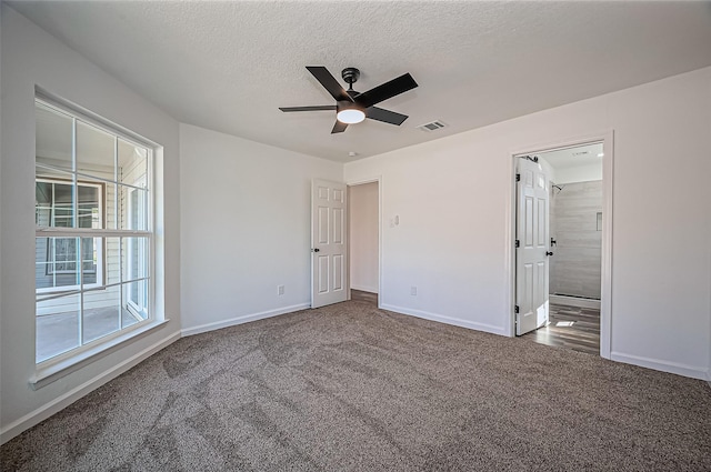 unfurnished bedroom with carpet, visible vents, a ceiling fan, a textured ceiling, and baseboards