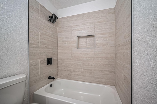 bathroom featuring toilet, shower / washtub combination, a textured ceiling, and a textured wall