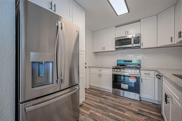 kitchen featuring white cabinets, decorative backsplash, dark wood-type flooring, light stone countertops, and stainless steel appliances