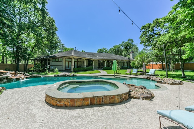 pool featuring a yard, fence, and an in ground hot tub