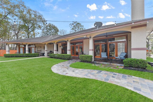 view of front facade featuring french doors, a front lawn, and stucco siding