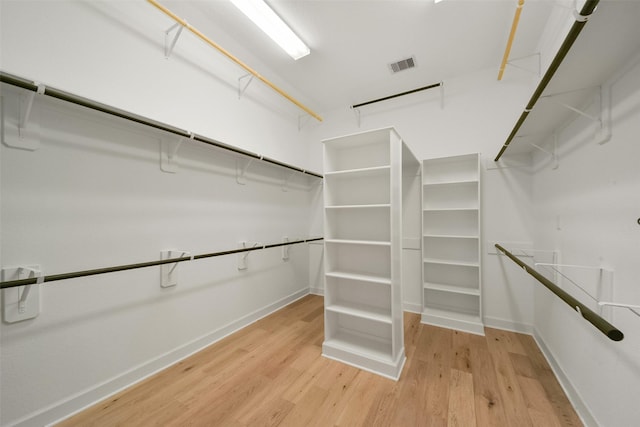 walk in closet with light wood finished floors and visible vents