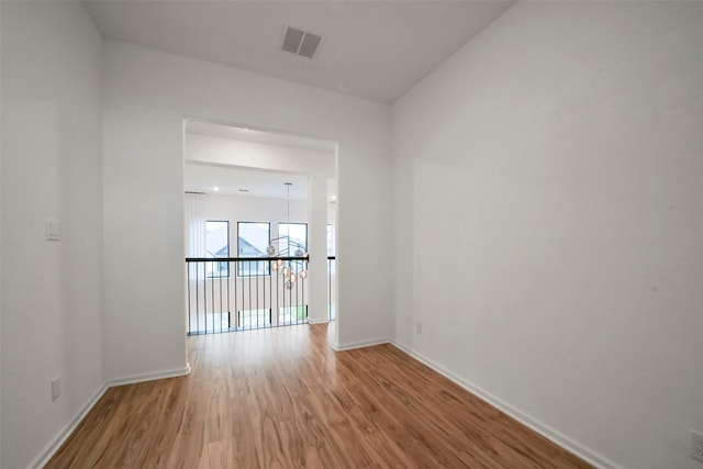 empty room featuring visible vents, baseboards, and wood finished floors