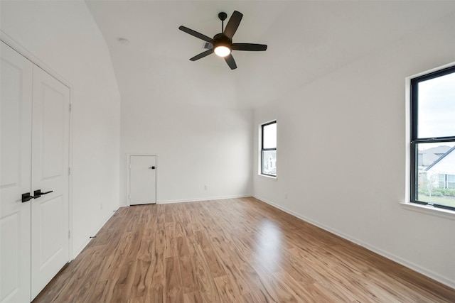 spare room featuring baseboards, plenty of natural light, a ceiling fan, and light wood-style floors