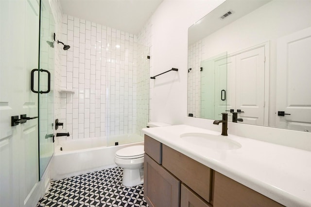 full bath featuring toilet, visible vents, combined bath / shower with glass door, and vanity