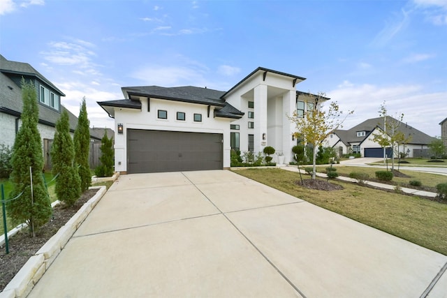 view of front of house with a garage, driveway, a front lawn, and stucco siding