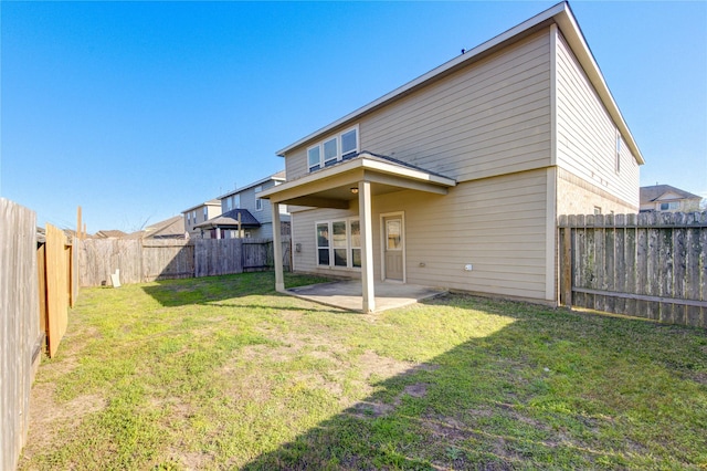 back of house with a yard, a fenced backyard, and a patio