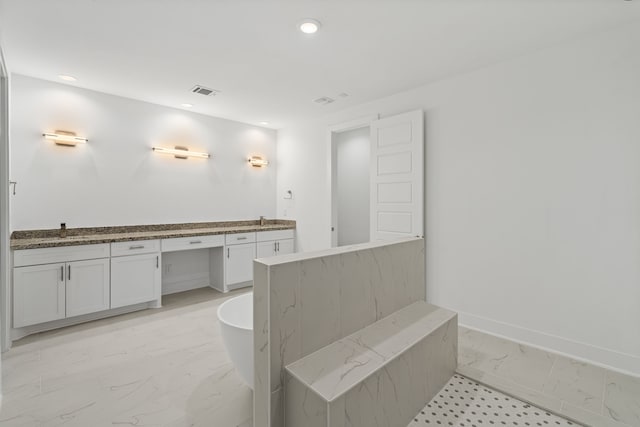 bathroom with visible vents, baseboards, a freestanding tub, marble finish floor, and recessed lighting