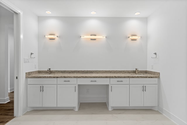 bathroom with marble finish floor, baseboards, and a sink