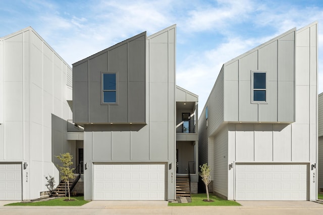 view of front of property featuring stairway, driveway, an attached garage, and board and batten siding