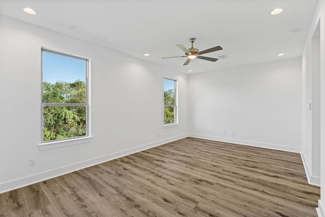 spare room with recessed lighting, baseboards, and wood finished floors