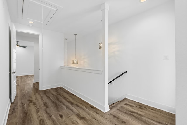 corridor with recessed lighting, attic access, baseboards, wood finished floors, and an upstairs landing