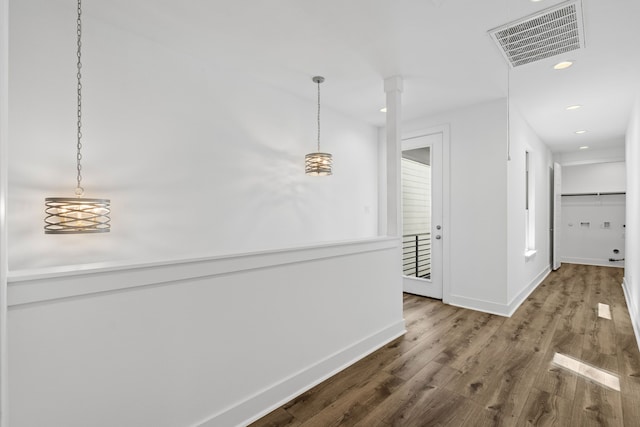 corridor featuring baseboards, recessed lighting, visible vents, and wood finished floors