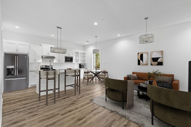 living area with light wood-style flooring and recessed lighting