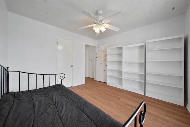 bedroom featuring ceiling fan, a textured ceiling, and wood finished floors