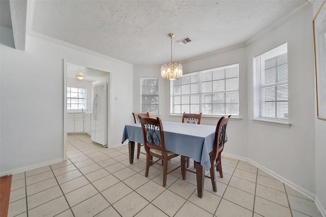 dining room with a textured ceiling, visible vents, a chandelier, and crown molding