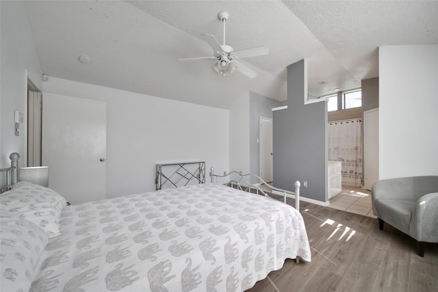 bedroom featuring a textured ceiling, a ceiling fan, vaulted ceiling, and wood finished floors