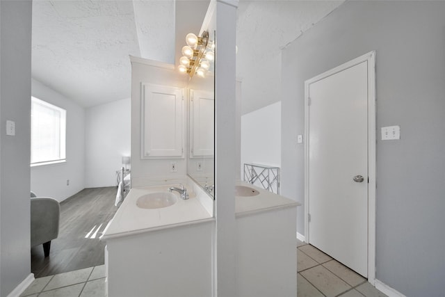 bathroom with a notable chandelier, tile patterned flooring, a textured ceiling, and vanity