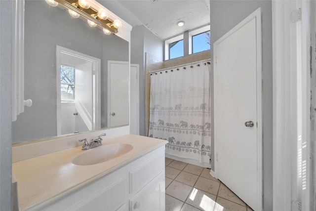 full bath with tile patterned flooring, a shower with curtain, vanity, and a textured ceiling