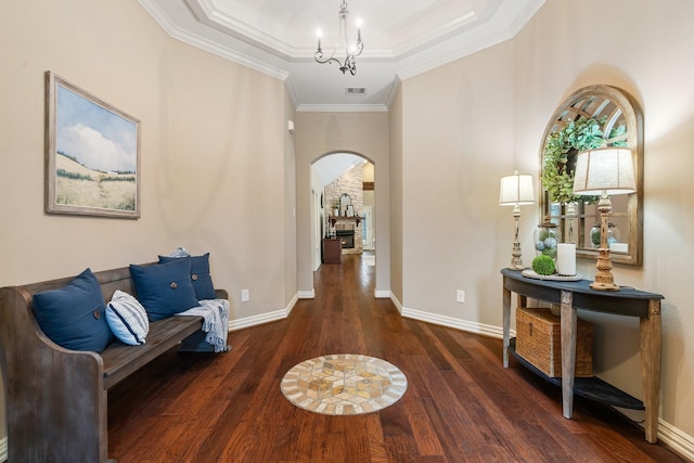 hall with visible vents, arched walkways, ornamental molding, hardwood / wood-style floors, and a tray ceiling