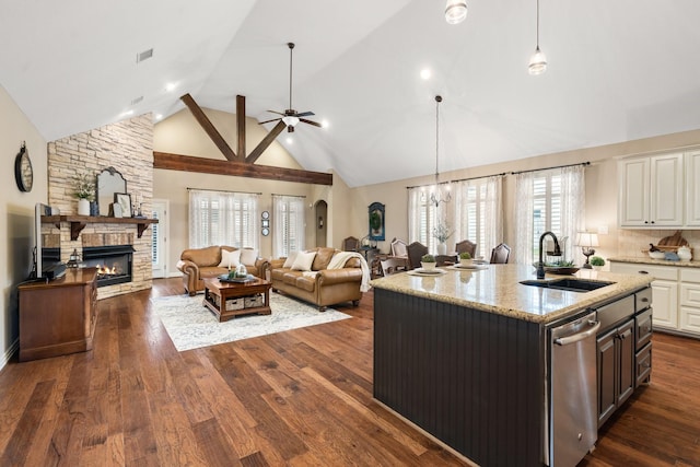 kitchen featuring visible vents, dishwasher, dark wood-style floors, a fireplace, and a sink