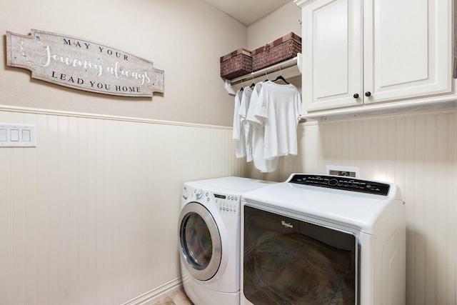 laundry area with a wainscoted wall, cabinet space, and washer and dryer