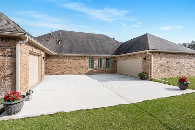 view of side of home featuring concrete driveway, brick siding, roof with shingles, and an attached garage