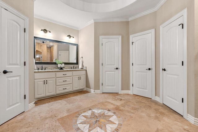 full bathroom featuring crown molding, a sink, baseboards, and double vanity