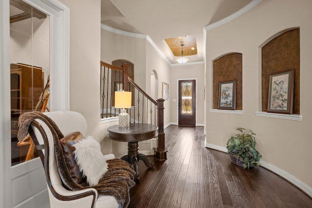 entryway with arched walkways, crown molding, stairway, hardwood / wood-style floors, and baseboards