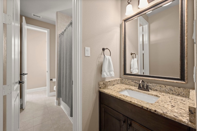 full bath with a shower with shower curtain, vanity, baseboards, visible vents, and tile patterned floors