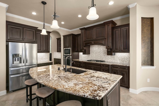 kitchen with a breakfast bar area, stainless steel appliances, dark brown cabinets, crown molding, and a sink