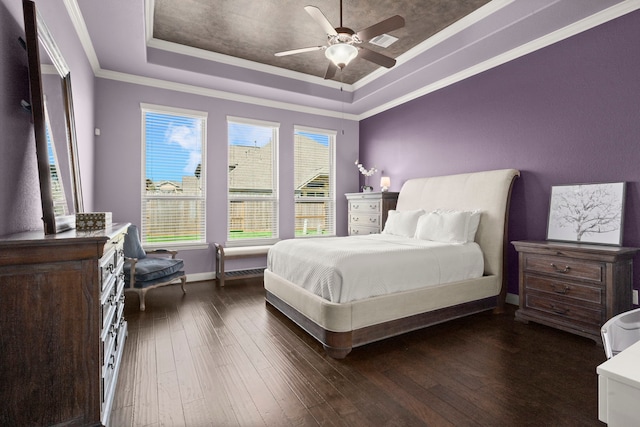 bedroom with baseboards, a raised ceiling, ceiling fan, ornamental molding, and dark wood-style flooring