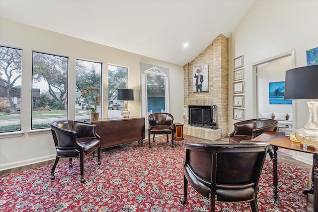 living room with a fireplace, vaulted ceiling, baseboards, and wood finished floors